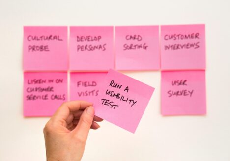 person holding pink sticky note
